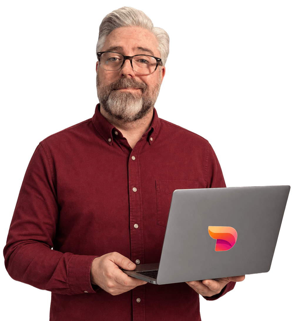 Jeremy Kenerson of DeskTeam360 holding a laptop, ready to support your team