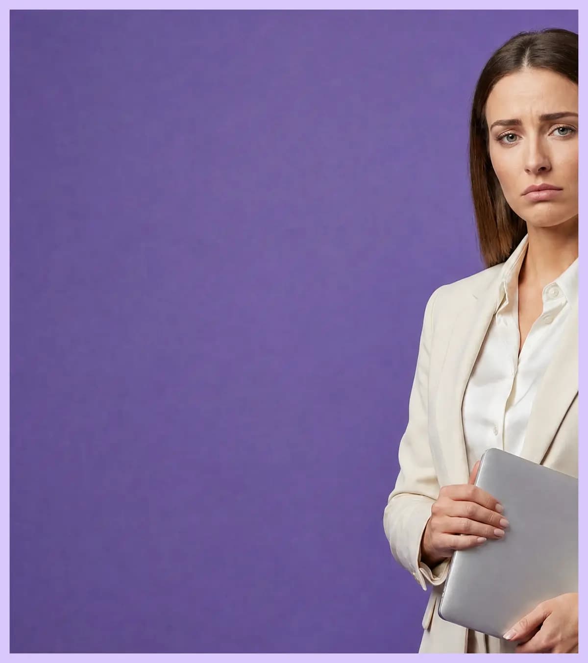 Frowning woman in a cream blazer holding a closed silver laptop.